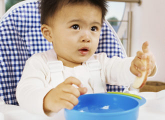 Bébé mangeant seul dans une assiette