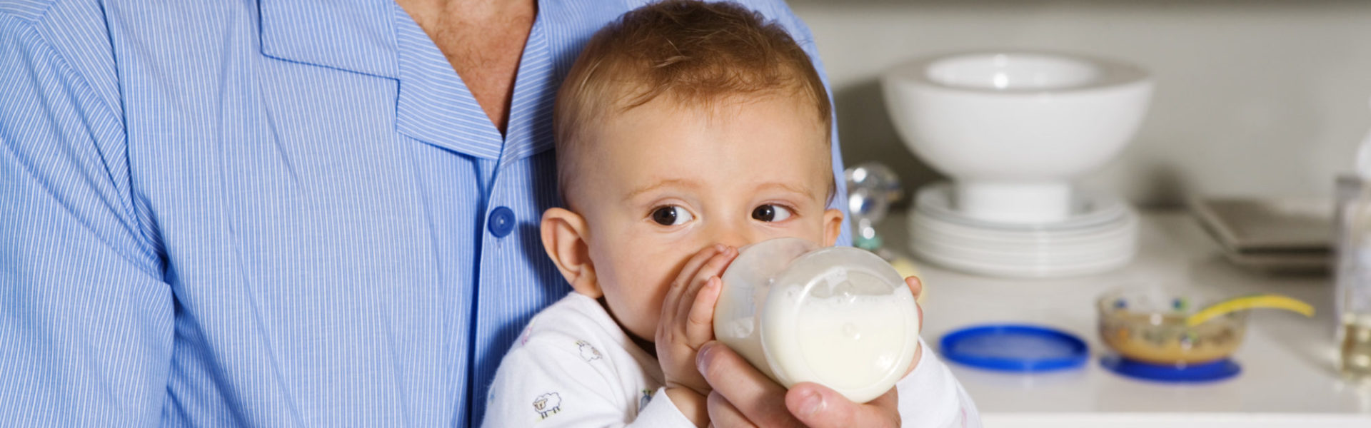 Bébé buvant le biberon dans les bras de Papa