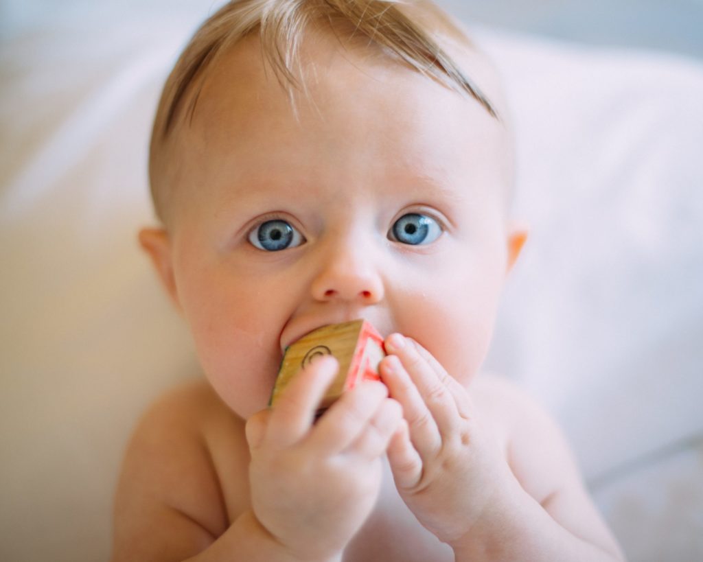 Bébé avec cube à la bouche